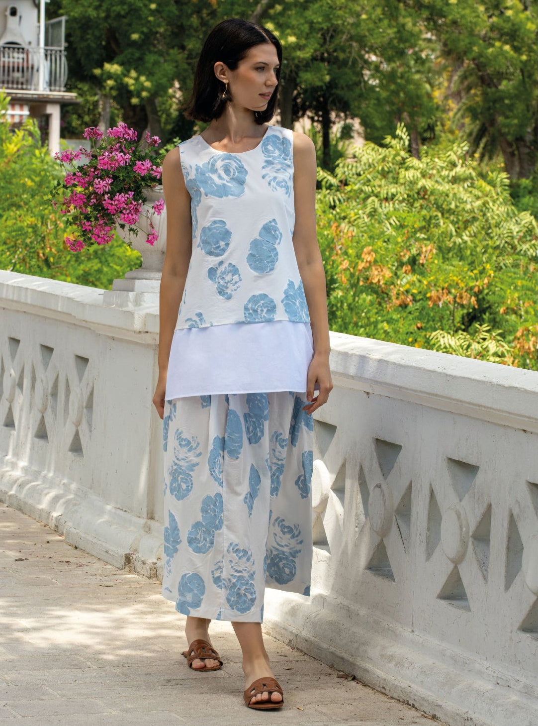 Canotta doppia con tessuto in contrasto, scollo tondo e stampa azzurra floreale su fondo bianco.